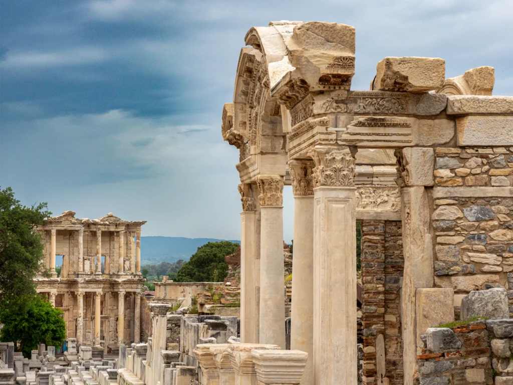 Explore the architectural beauty of the ancient Roman ruins of Ephesus under a dramatic cloudy sky.